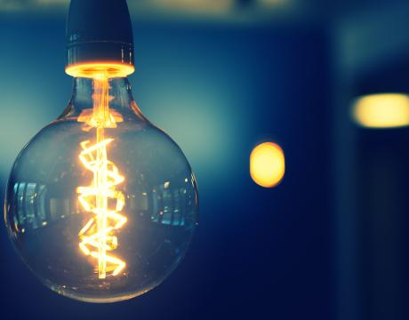 A bright lightbulb against a faded blue background