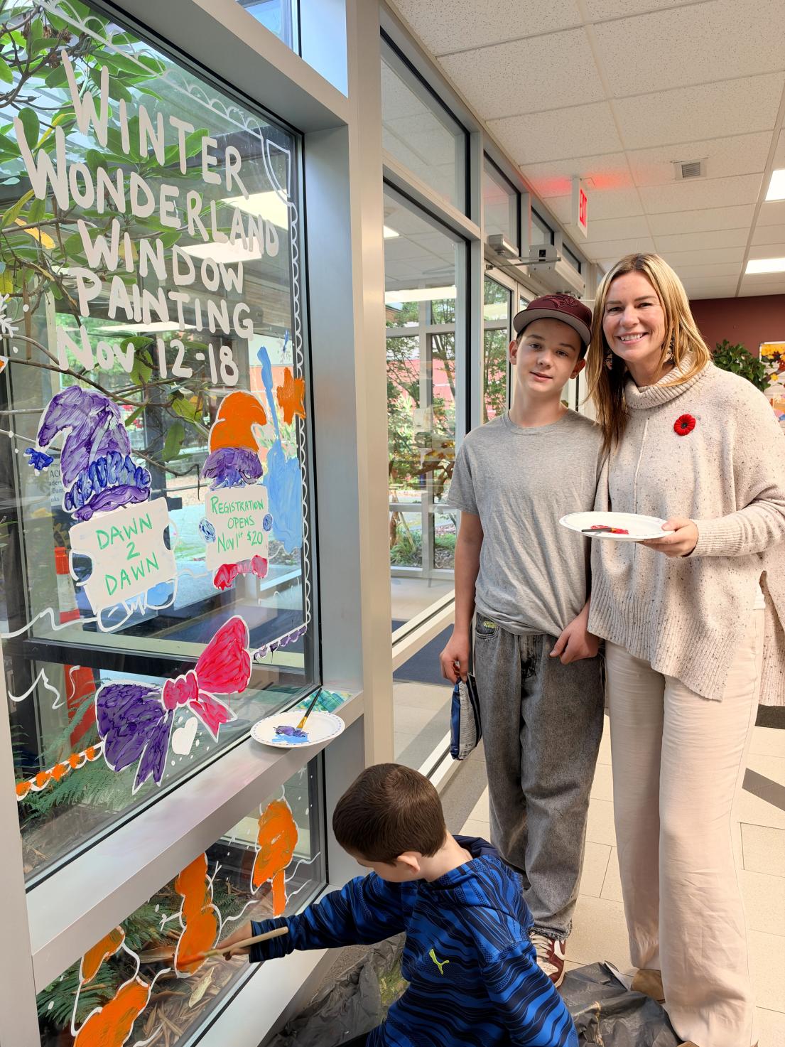 Mayor with family painting windows